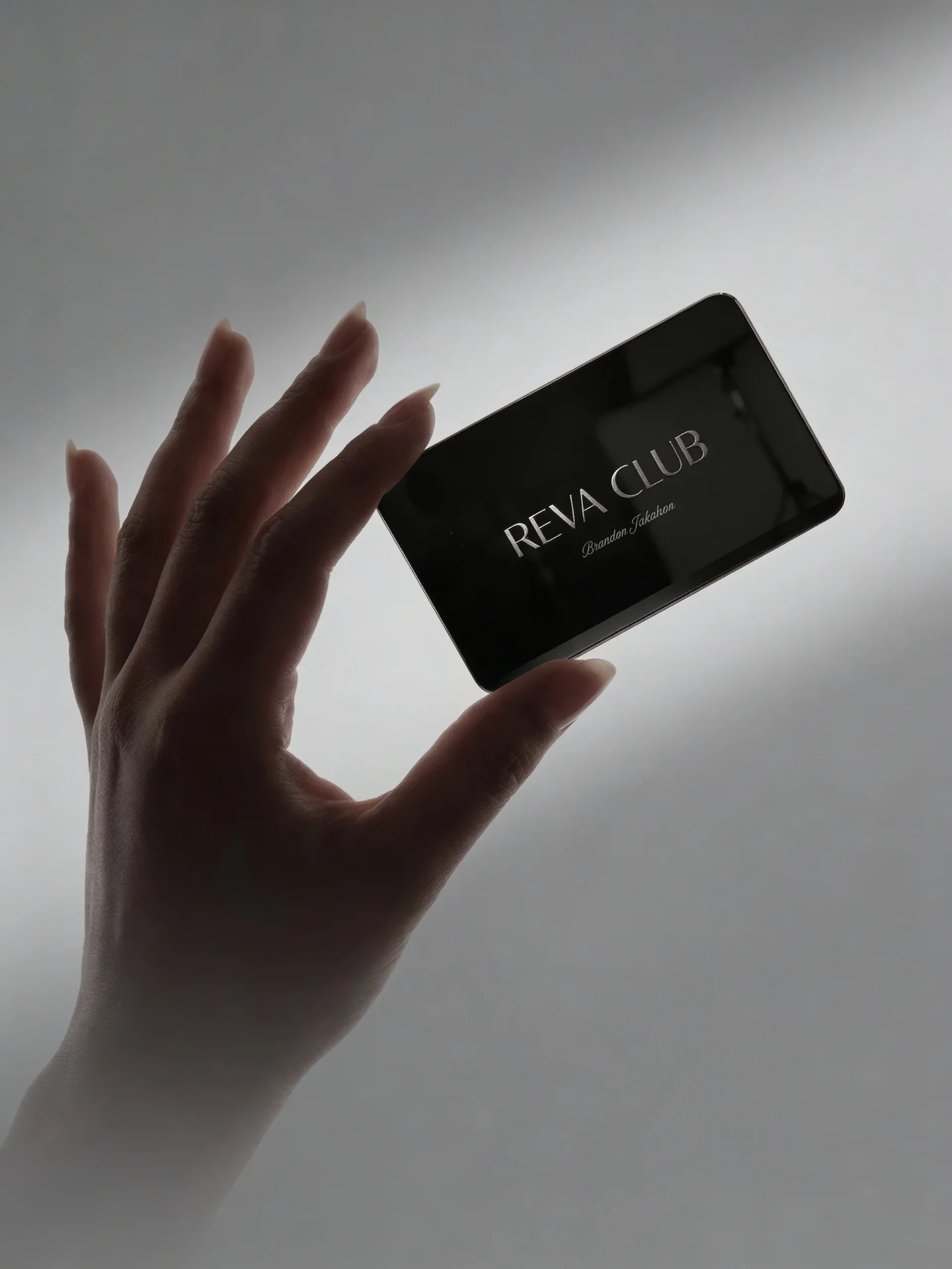 A hand holding the Reva Club card